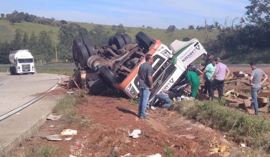 Motorista fica preso às ferragens após carreta carregada com dormentes de madeira tombar na BR-163 em Lindoeste