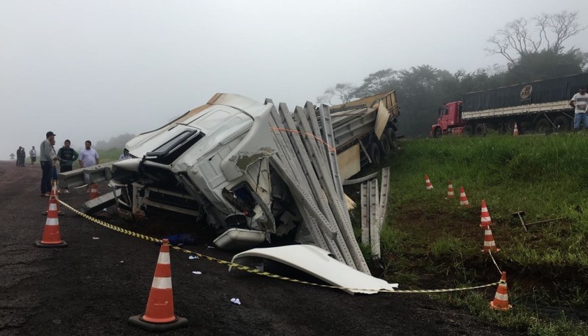 Três caminhões batem e motorista morre embaixo de postes